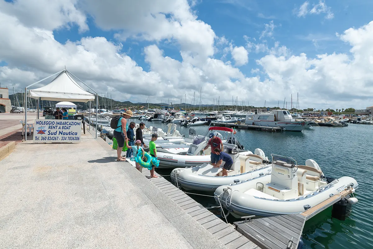 Sud Nautica famiglia turisti stranieri noleggiano gommone al porto di Villasimius